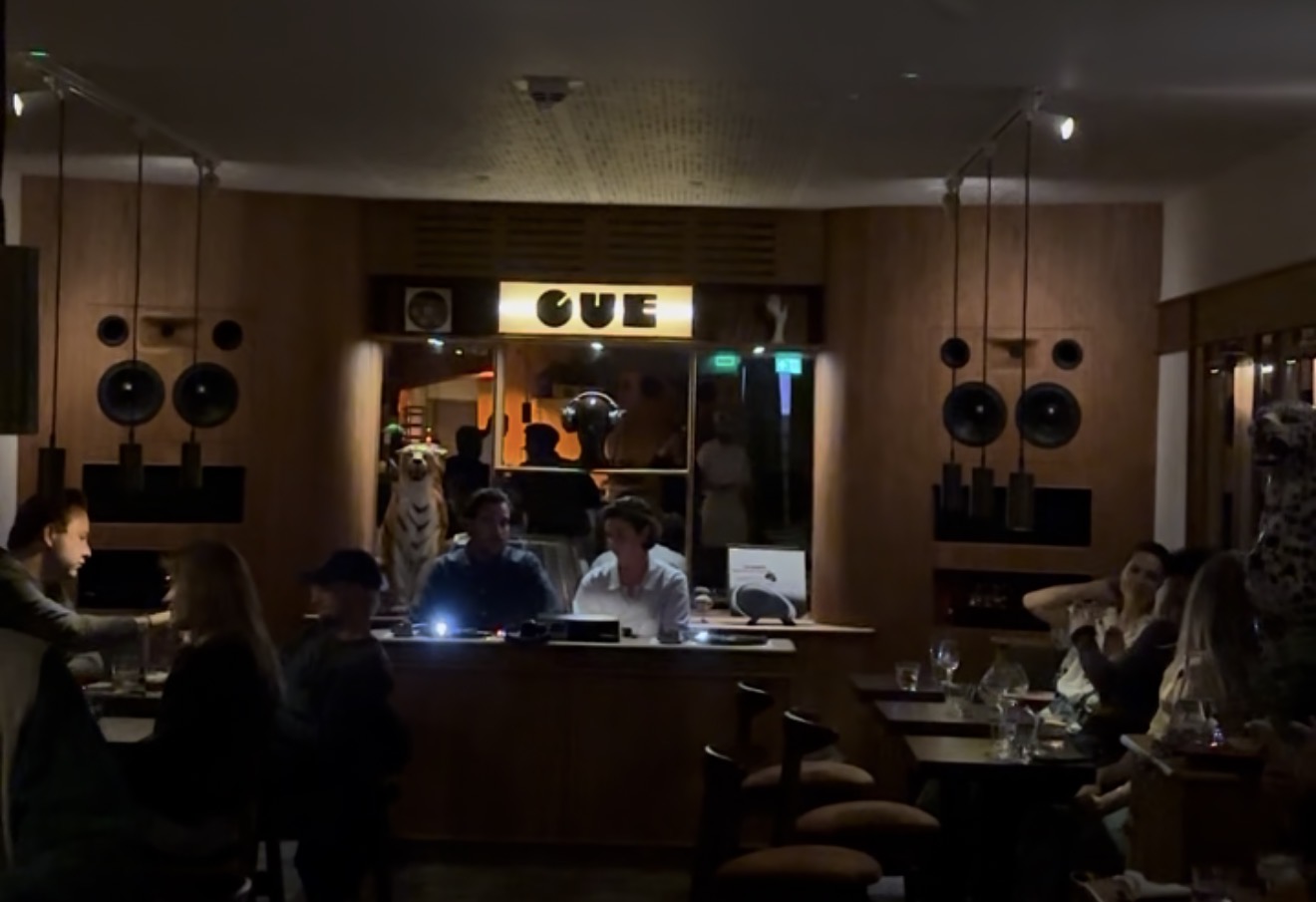 An evening in CUE’s listening room, with speakers flanking the DJ booth.
